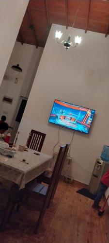 a living room with a table and a flat screen tv on the wall at White villa resort dodangoda in Kalutara