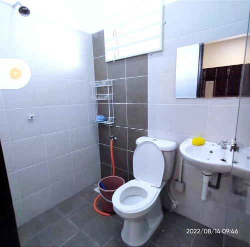 ein Bad mit einem WC und einem Waschbecken in der Unterkunft HOMESTAY NAFISAH in Tapah Road