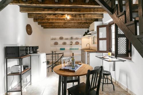a kitchen and dining room with a table and chairs at Casa Mourisca - Albino d'Óbidos in Óbidos