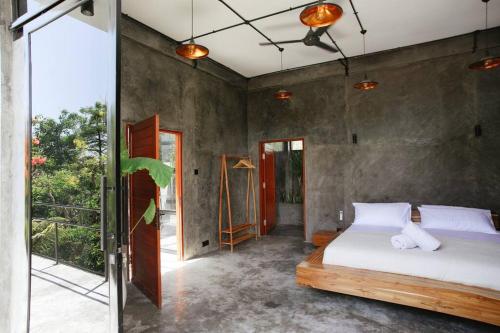 1 dormitorio con 1 cama y puerta de cristal en Uluwatu Luxury Villa with private pool and sauna- Villa Cumi Cumi en Uluwatu
