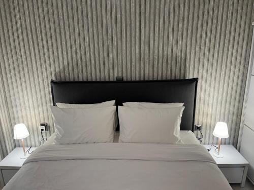 1 dormitorio con 1 cama con 2 lámparas en 2 mesas en Metropolitan Complex Apartment Faliro, en Pireo