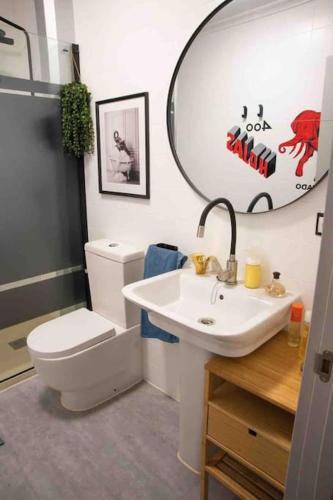 a bathroom with a toilet and a sink and a mirror at La casa del elefante in Valladolid
