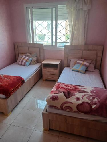um quarto com 2 camas e uma janela em Super appartement avec parking gratuit em Oujda