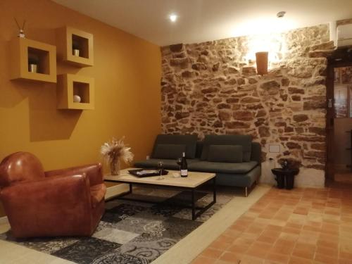 a living room with couches and a stone wall at Contact Hôtels Le Savigny & Spa in Blacé