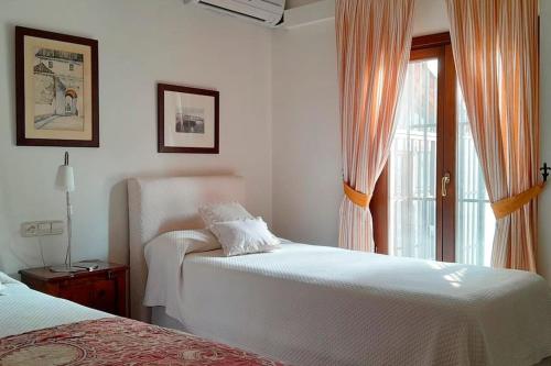 阿茲納爾卡扎爾的住宿－La Propiedad de la Mirada，一间白色卧室,配有两张床和窗户