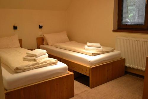 Habitación con 2 camas individuales y toallas. en Vila 3 Stromy sk, en Modra