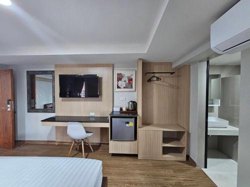 โรงแรมเซเว่นรัชดา S7VEN RATCHADA في Ban Na Song: غرفة بسرير ومطبخ مع تلفزيون