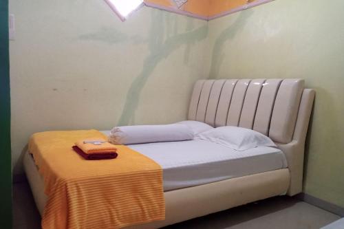 a small bed in a room with a blanket on it at OYO 93532 Kost Nian Syariah in Parepare