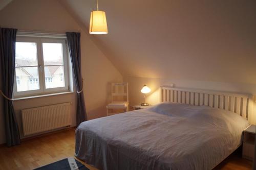 a bedroom with a bed and a large window at Maritim eingerichtete Fewo mit Balkon, 2 Fernsehern in Kühlungsborn