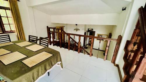 a dining room with a table and a balcony at White Grand Hotel in Balangoda