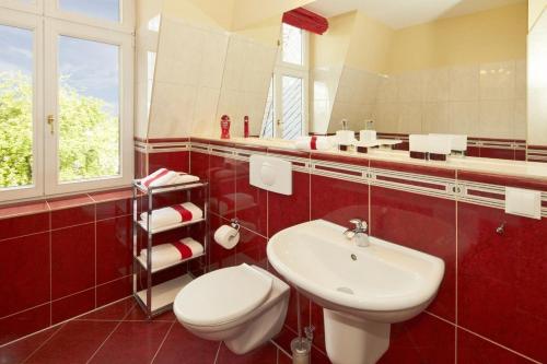 uma casa de banho com um WC branco e um lavatório. em Villa Hintze em Heringsdorf