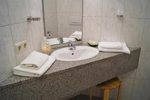 un comptoir de salle de bain avec un lavabo et un miroir dans l'établissement Strandnahe Fewo mit Balkon, WLAN-Anschluss & PKW-Stellplatz, à Kühlungsborn