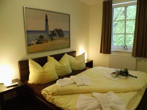 Un dormitorio con una cama con toallas blancas. en Komfortable Fewo - modern, strandnah, Balkon, mit Wellnessbereich, en Baabe