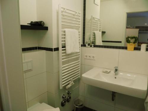 Baño blanco con lavabo y espejo en Komfortable Fewo - modern, strandnah, Balkon, mit Wellnessbereich, en Baabe