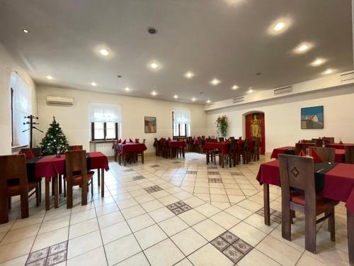 un comedor con mesas y sillas rojas y un árbol de Navidad en Gostišče Barbara, en Idrija