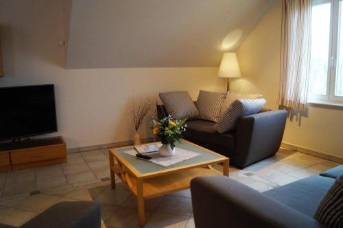 a living room with a couch and a coffee table at Luxus-Fewo mit 2 Slz, 2 Bädern und Meerblick in Ahlbeck