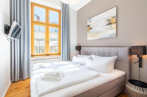 a white bed in a room with a window at Großzügige Designer- Luxuswohnung für 2 Personen in stilvoller Altbauvilla in Heringsdorf