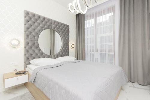 華沙的住宿－Wilanów Holzera Elegant Apartment with Balcony & Parking by Renters，白色卧室设有一张大床和镜子