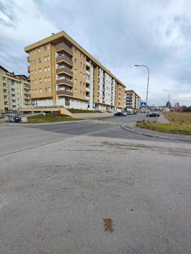 an empty street in front of a large building at Stan na dan Apartman KRISFIL Prnjavor in Prnjavor