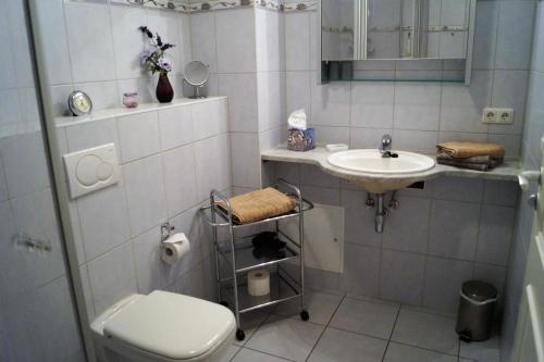 a white bathroom with a sink and a toilet at Casa Nova, Wohnung 16 in Kühlungsborn
