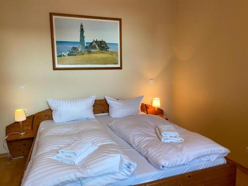 ein Bett mit zwei Kissen und einem Bild an der Wand in der Unterkunft attraktive Fewo: 100 m zum Strand, WLAN, Fahrräder in Heringsdorf