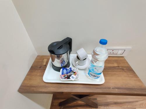 a table with a coffee maker and a bottle of water at Flexi Hospitality-Hotel 56 -अमृतसर का सबसे सस्ता होटल in Amritsar