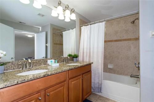 een badkamer met 2 wastafels en een grote spiegel bij 4 Bedrooms- 3bathrooms- Paradise Palms 8986cp in Kissimmee