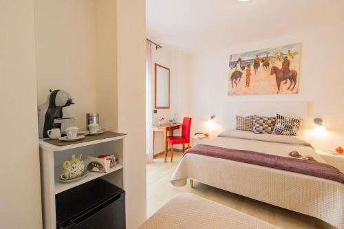 a bedroom with a bed and a desk with a red chair at Hotel Paistos Paestum in Paestum