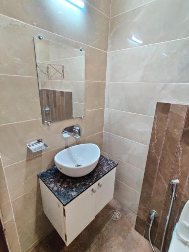een badkamer met een wastafel en een spiegel bij Flexi Hospitality-Hotel 56 -अमृतसर का सबसे सस्ता होटल in Amritsar