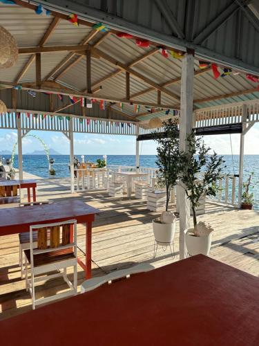 eine Holzterrasse mit einem Picknicktisch und dem Meer in der Unterkunft BIHING ANGAN water chalet in Semporna