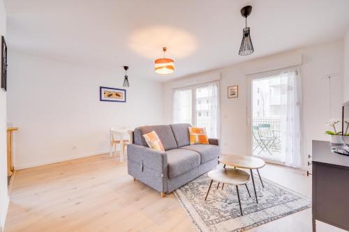 un salon avec un canapé et une table dans l'établissement L'Arboresens - Appt avec terrasse et parking, à Mérignac