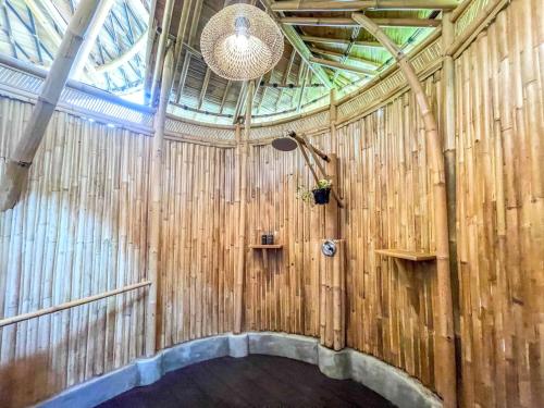 una habitación con una pared de madera con una luz en ella en Eco Bamboo Island Bali - Bamboo House #3, en Selat