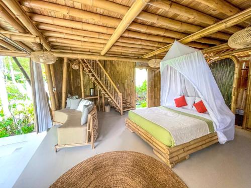 1 dormitorio con 1 cama y 1 silla en una habitación en Eco Bamboo Island Bali - Bamboo House #3, en Selat