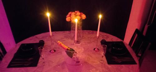 a pink table with two candles on top of it at LIVABLŌM " Petit Dej Offert " in Guesnain