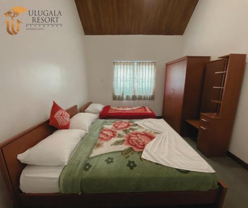 a bedroom with a bed with a flower blanket on it at Ulugala Resort in Nuwara Eliya