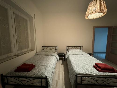 two twin beds in a room with a window at Lavanda House in Vicenza