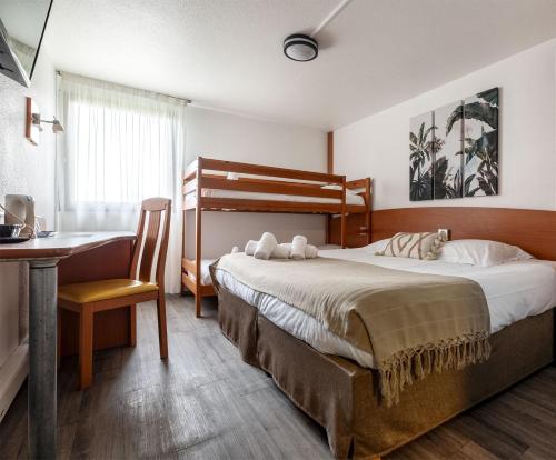 een hotelkamer met een bed, een bureau en een bureau bij Les Dépendances Du Cyrano in Bergerac