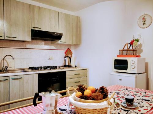 una cocina con una mesa con una cesta de fruta. en Casa rurale Colleccio - colline di Lucca, en Fibbialla