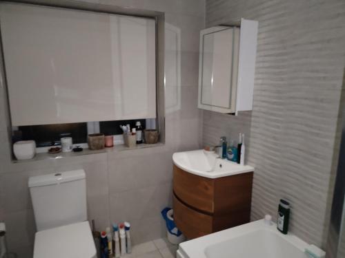 a bathroom with a white toilet and a sink at single room available in Harpenden