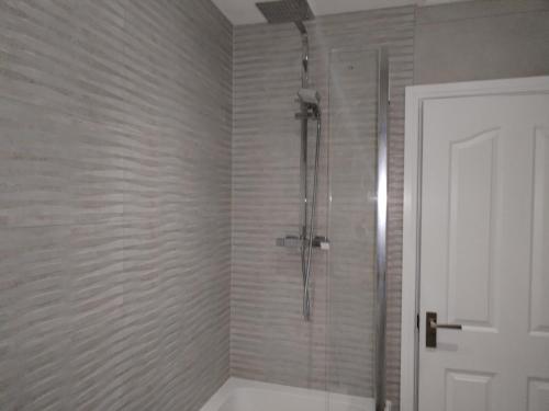 a bathroom with a shower with a glass door at single room available in Harpenden