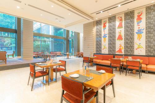 海得拉巴的住宿－海得拉巴萬怡酒店，餐厅设有桌椅和窗户。