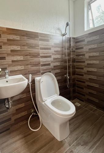 a bathroom with a toilet and a sink at Alicia's Guest House in Butuan