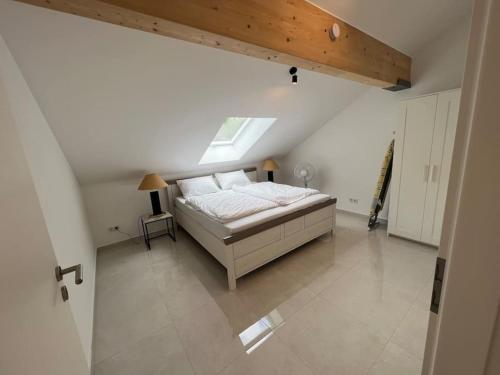 um quarto branco com uma cama num sótão em DG-Wohnung in Starnberg Nord em Starnberg