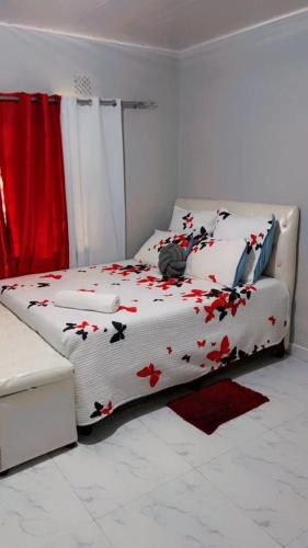 Un dormitorio con una cama con flores rojas. en Beautiful adventure, en Chichili