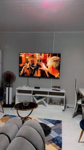 uma sala de estar com uma televisão de ecrã plano na parede em Beautiful adventure em Chichili