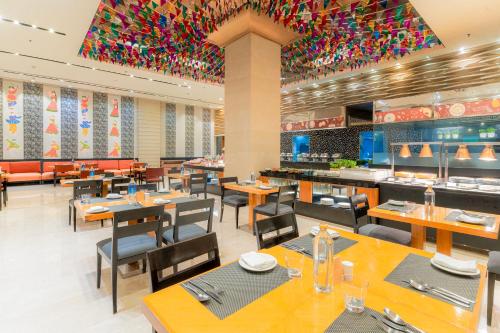 a dining room with tables and chairs and a restaurant at Courtyard by Marriott Hyderabad in Hyderabad