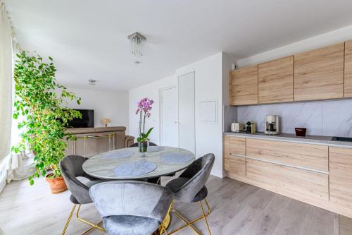 une cuisine et une salle à manger avec une table et des chaises dans l'établissement Appartement Palaric - Welkeys, à Saint-Ouen