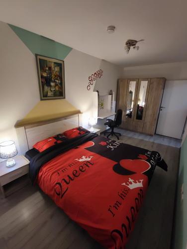 a bedroom with a large bed with a red comforter at Stan na dan Apartman KRISFIL Prnjavor in Prnjavor