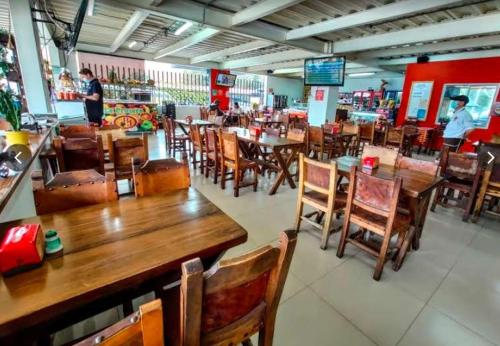 un comedor con mesas de madera y sillas en un restaurante en STAR HOTEL & CLUB DE TENIS, a 2 pasos del Aeropuerto JMC, Transporte Incluido en Rionegro