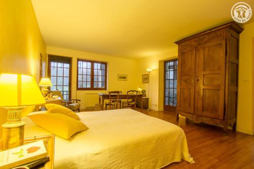 a yellow bedroom with a bed and a wooden cabinet at Gite des Sources d'Arvey in Verrens-Arvey